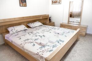 地拉那City Center Two Private Bedrooms near Scanderbeg Square on Shared Apartment的一间卧室配有一张带木制床头板和镜子的床