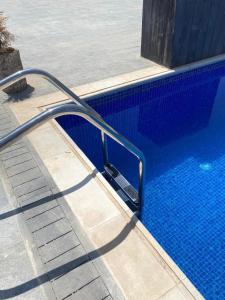 Al RamaThe Mansion villa的游泳池旁边设有金属扶手