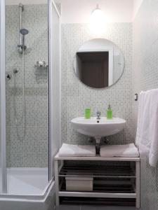 罗马多莫斯科里森吉奥 - 旅馆的浴室配有盥洗盆和带镜子的淋浴
