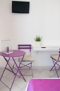 罗马多莫斯科里森吉奥 - 旅馆的电视室里一张紫色的桌子和椅子