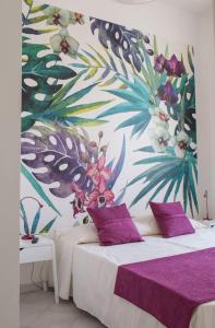罗马多莫斯科里森吉奥 - 旅馆的一间卧室配有两张带紫色枕头的床和花卉墙