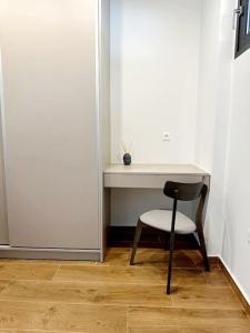 比雷埃夫斯Moschato New Home 3 vipgreece的白色墙壁旁的一张桌子和椅子