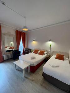 艾克斯莱班Authentic by Balladins, Le Carré d'Aix的酒店客房设有两张床和一张桌子。