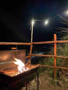 库斯科Ecolodge las tunas的夜间在栅栏前的火烤架