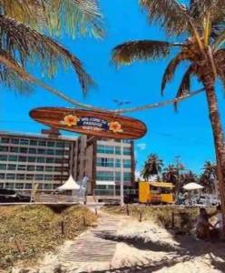 卡贝德卢Lindo Flat completo em Intermares 404的挂在楼旁棕榈树上的冲浪板