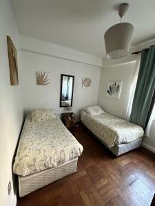圣地亚哥德尔塞罗旅馆的一间卧室配有两张床和镜子