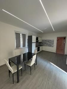 托尔托纳Appartamento Tortona的一间用餐室,配有黑桌和白色椅子
