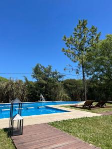 拉巴斯don isidro cabaña alta的游泳池旁设有木制走道和长凳