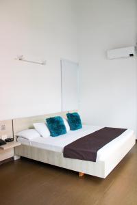 布卡拉曼加BGA酒店 的客房内的白色床和蓝色枕头
