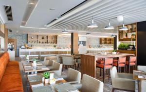 拉斯阿尔卡麦希尔顿哈伊马角酒店的一间带桌椅的餐厅和一间酒吧
