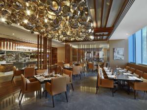 迪拜迪拜V希尔顿格芮酒店的一间带桌椅和吊灯的用餐室