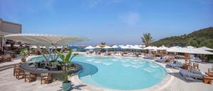 博德鲁姆Susona Bodrum, LXR Hotels & Resorts的一个带椅子和遮阳伞的大型游泳池