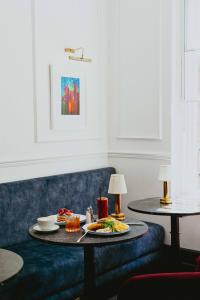 利物浦Lock and Key Boutique Hotel - Duke Street的一张桌子,上面有盘子的食物放在蓝色的沙发上