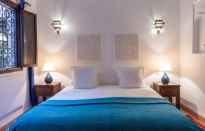 马拉喀什索斯贝皮尔摩洛哥传统庭院住宅的一间卧室配有一张床,两台桌子上放着两盏灯