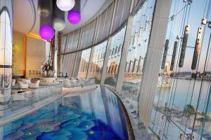 阿布扎比Conrad Abu Dhabi Etihad Towers的大型室内游泳池,位于带大窗户的建筑内