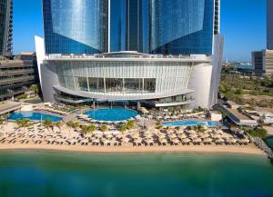 阿布扎比Conrad Abu Dhabi Etihad Towers的享有带椅子和游泳池的度假村的空中景致