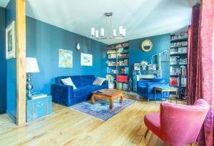 特鲁瓦Le Cordelier - Jardin en plein centre - Quais de Seine的客厅拥有蓝色的墙壁和蓝色的沙发