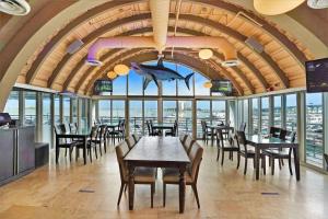 迈阿密Seas The Day! Complete Panoramic Water Views的一间带桌椅的餐厅和一间大窗户的大房间