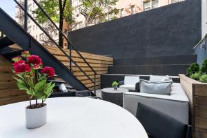 纽约Unbeatable 3BR with Private Patio in Upper East Side的庭院配有白色的桌椅和楼梯。