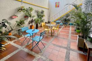 佩雷拉Casa Azul Boutique Hostel的一个带桌椅和盆栽的庭院