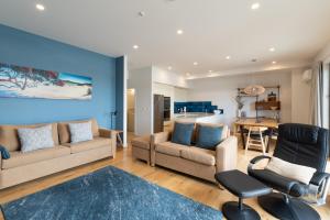OpuaBay of Islands Apartment with Marina Views的客厅配有沙发、椅子和桌子