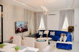 拉各斯Luxury 4bed Harris Drive Lekki的客厅配有蓝色的沙发和桌子