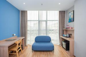 上海上海未来上居酒店的客房设有蓝色椅子、书桌和窗户。