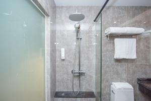 上海上海未来上居酒店的浴室设有玻璃淋浴间和卫生间