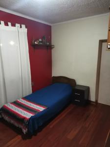 瓦尔帕莱索Casa del Limón的一间卧室设有蓝色的床和红色的墙壁