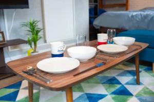 东京Yoyogi Apartment 1-401的一张木桌,上面放有盘子和碗