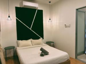 东贡岸Stylish 2 Bedroom Apartment by Thirteen Residence at ITCC Manhattan suites TR09的一间卧室配有一张带绿色床头板的床