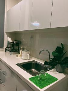 东贡岸Stylish 2 Bedroom Apartment by Thirteen Residence at ITCC Manhattan suites TR09的厨房水槽上装有绿色海绵