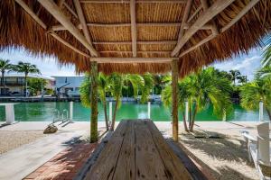 Summerland KeyRelaxing 2 2 Get Away in the Lower Keys! home的海滩上草伞下的木凳