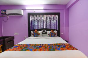 普里FabHotel Bollywood 2.0的一间卧室配有一张紫色墙壁和窗户的床