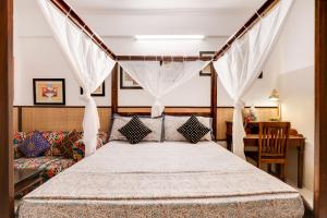 诺伊达House of Comfort Noida的一间卧室配有天蓬床和沙发