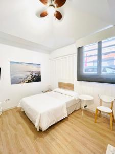贝尼卡西姆Suites Puente de Hierro的白色卧室配有床和吊扇