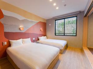 富士河口湖Rakuten STAY VILLA Fuji Kawaguchiko Forest 2LDK with sauna and terrace的酒店客房设有两张床和窗户。