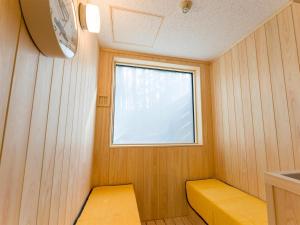 富士河口湖Rakuten STAY VILLA Fuji Kawaguchiko Forest 2LDK with sauna and terrace的小房间设有黄色长凳和窗户