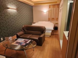 Koshigayaスタイリッシュ武里的酒店客房设有一张沙发和一张床