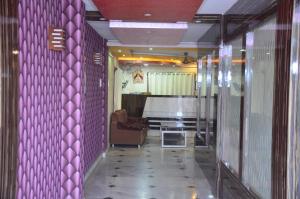 加尔各答Hotel Sweet Dream的一个带紫色墙壁的走廊和一个带沙发的房间