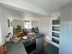 温德米尔Perfectly Located, Central Bowness Flat With Free Parking and Lake Views的厨房以及带炉灶烤箱的客厅。