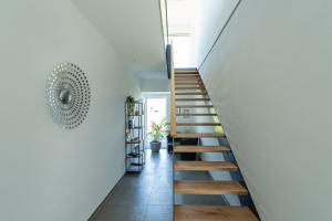 巴特武尔察赫Chalet am Ried的房屋内的楼梯,拥有白色的墙壁和木地板