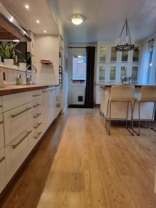 博伦厄Riverside villa的厨房铺有木地板,配有白色橱柜。