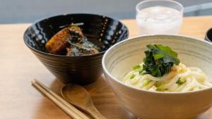 东京TOKIO's HOTEL的木桌上摆着两碗带筷子的食物