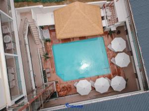 科隆Tropicasa Coron Resort & Hotel的享有带遮阳伞的游泳池的顶部景致