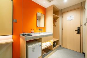 广州维福顿酒店（小北地铁站东海大厦店) - 广交会期间免费穿梭巴士的浴室配有水槽和橙色墙壁。