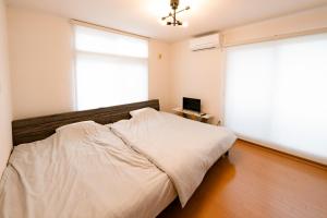函馆Villa Futaba若松町的一间卧室设有一张床和一个大窗户