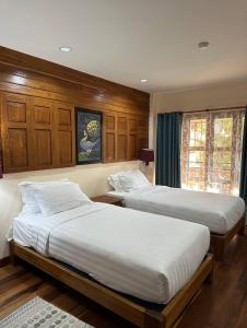 Ban Pa Sangบ้านยุ้งฮีลล์รีสอร์ท Baan Yung Hill Resort的卧室设有2张床和木镶板