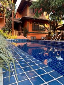 Ban Pa Sangบ้านยุ้งฮีลล์รีสอร์ท Baan Yung Hill Resort的房屋前带椅子的游泳池