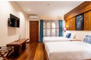 Ban Pa Sangบ้านยุ้งฮีลล์รีสอร์ท Baan Yung Hill Resort的酒店客房设有两张床和电视。